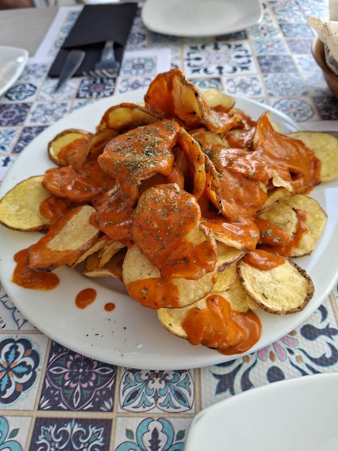 Patatas bravas en rodajas con salsa