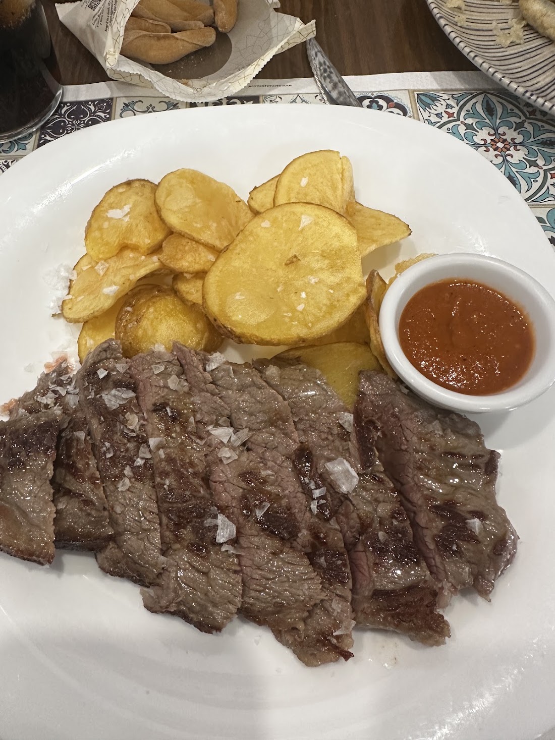 Carne en filetes con patatas fritas y salsa